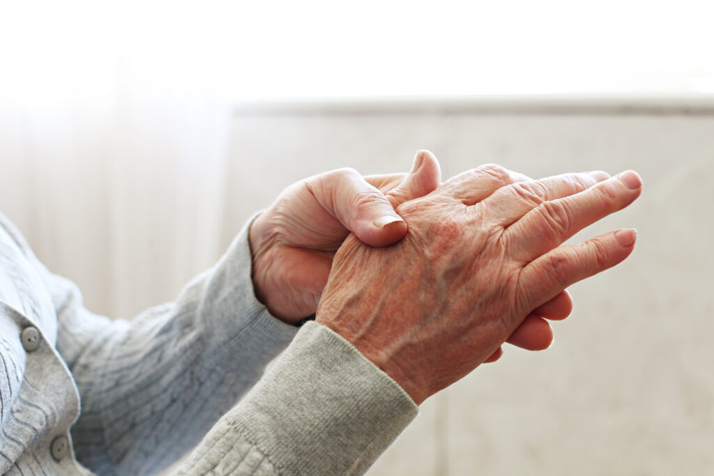 Elderly woman applying moisturising lotion cream on hand palm, easing aches. Senior old lady experiencing severe arthritis rheumatics pains, massaging, warming up arm. 