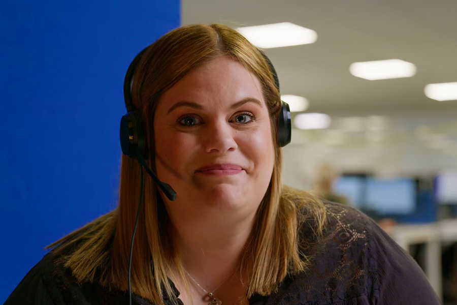 A woman in a headset looking at the camera with a smile.