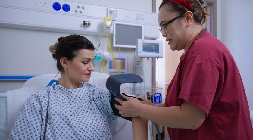 Nurse putting blood pressure band on patient