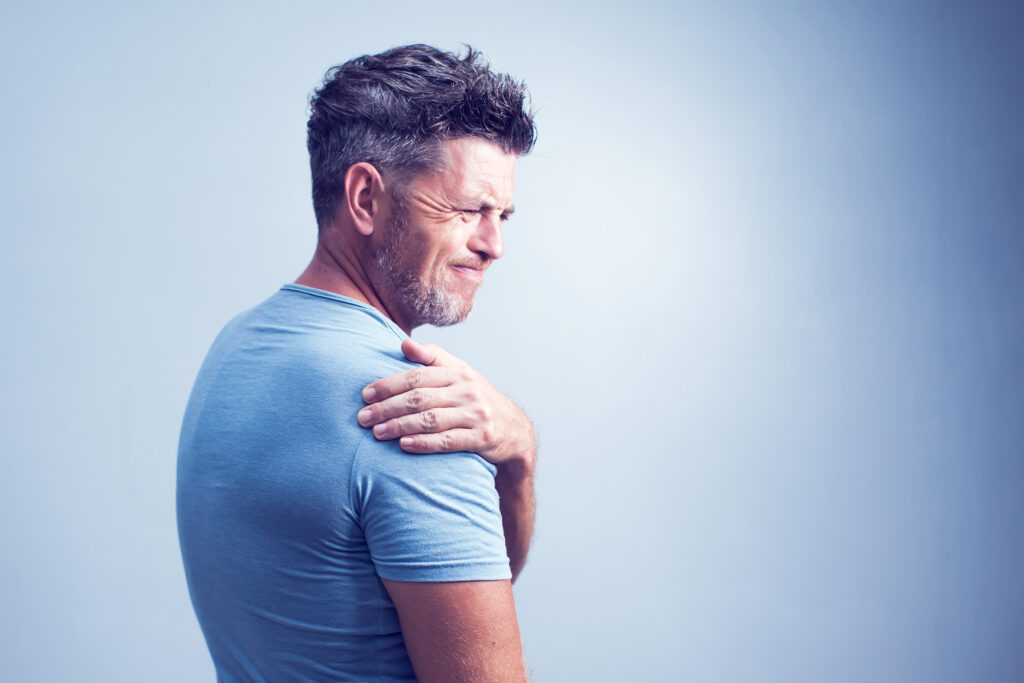 People, healthcare and problem concept - unhappy man suffering from neck or shoulder pain at home