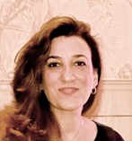 A headshot of Dr may Fadhil. She has long dark hair and is smiling towards the camera.