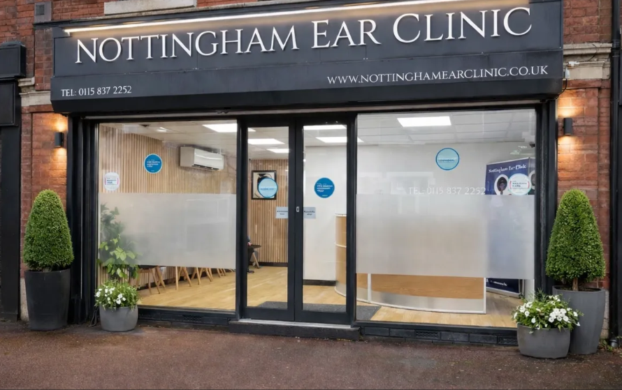 Small shop front glass shop front with "Nottingham ear clinic" sign above in grey