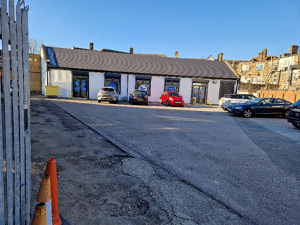 Parsloes hub a long white building with a car park attached.