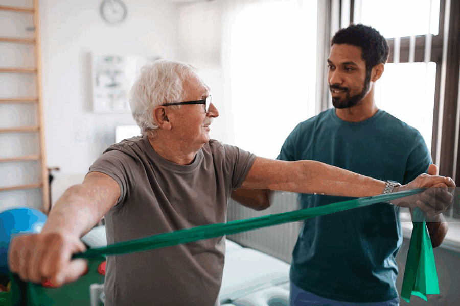 Older man using band to exercise with physio