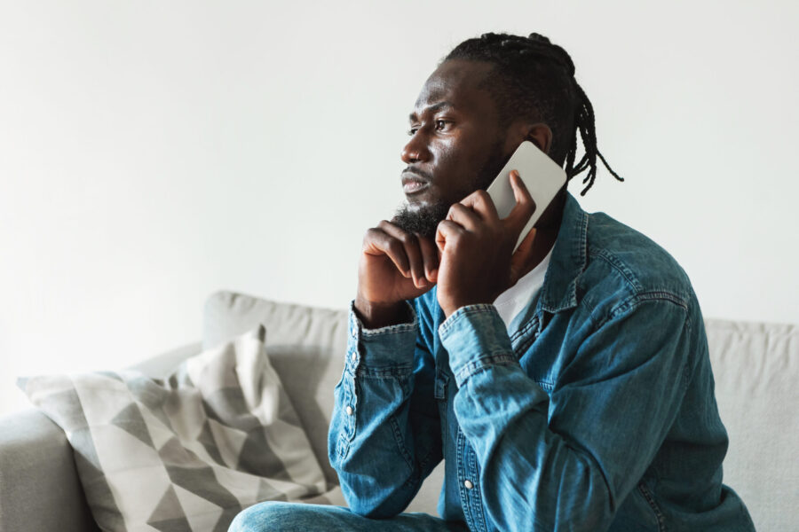 Man speaking on phone on sofa