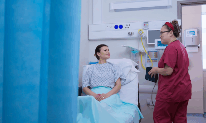 Nurse speaking to patient in bed